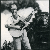 Ray Owen playing guitar in railroad attire