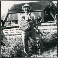 Ray Owen in farming clothes holding a banjo